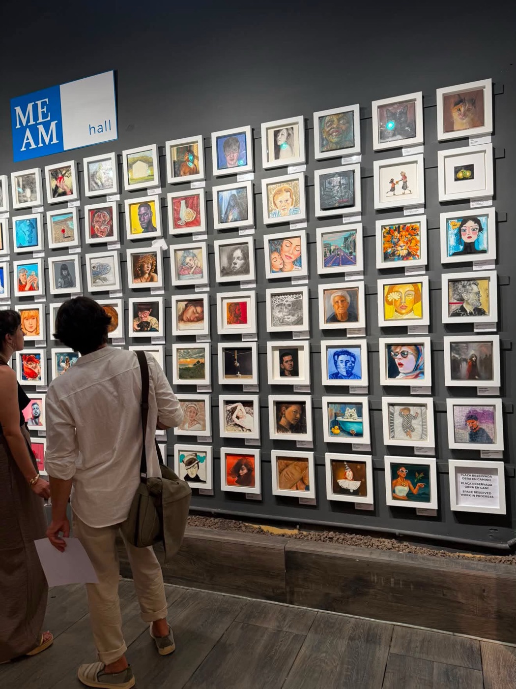 The MEAM Hall opening night — gallery wall with 20 × 20 cm works at MEAM, Barcelona, including Nuevos Horizontes by Angie Rangel